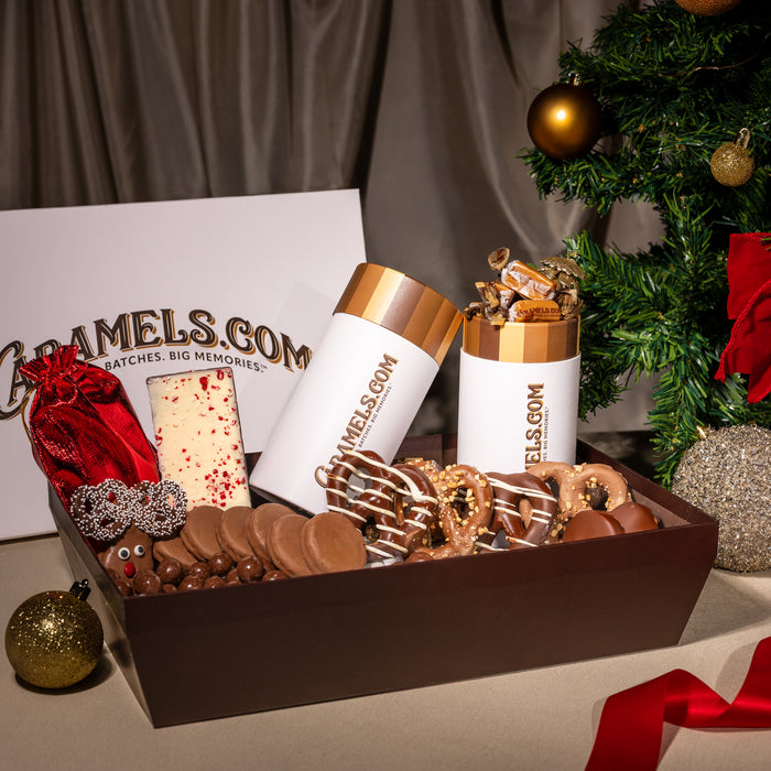 Chocolate gift set with 'Caramels.com' branding in front of a Christmas tree.